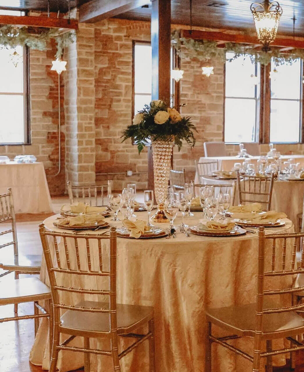 Round reception table with gold chiavari chairs and full place settings